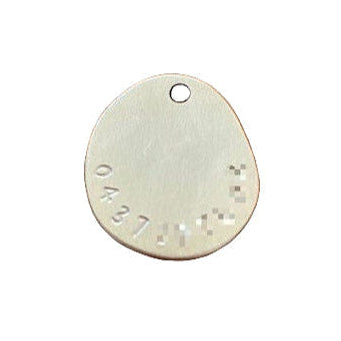 Metallic oval tag with engraved text on a white background