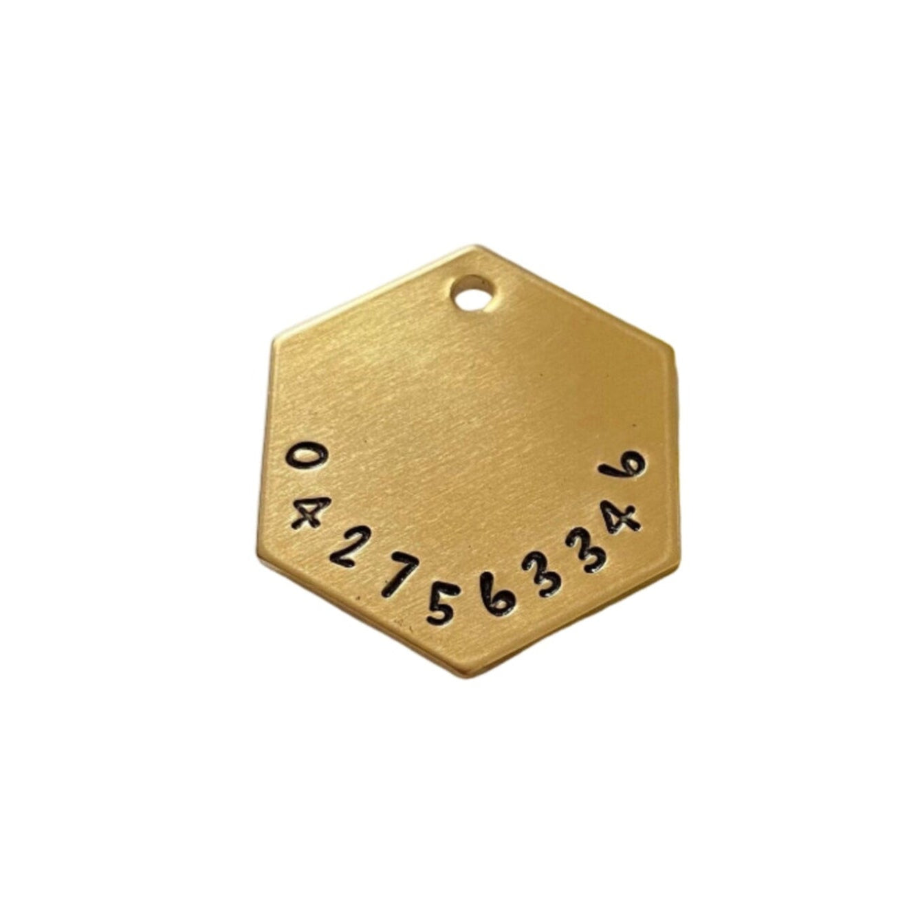 Gold hexagonal dog tag with numbers on back