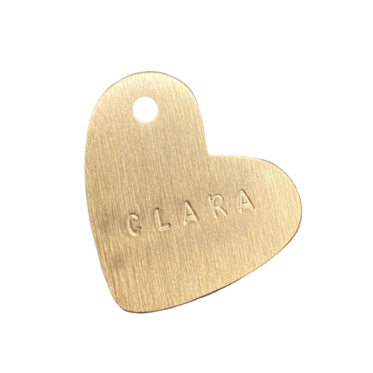 Gold heart-shaped tag with 'CLARA' engraved on a white background