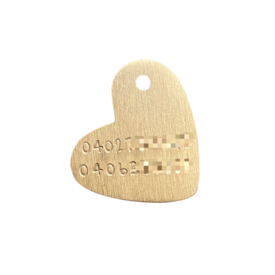 Gold heart-shaped tag with engraved text on a white background